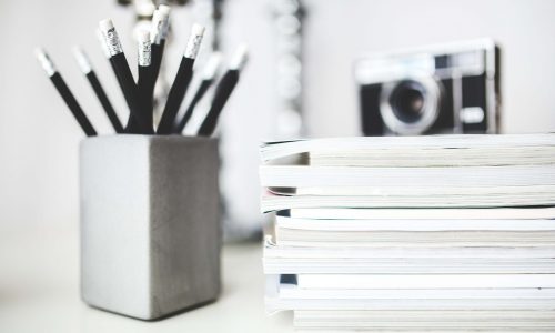 stack-of-magazines-pencils-in-gray-cup-6440-scaled